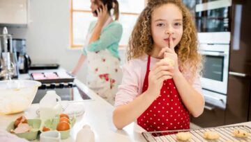 daughter-taking-cookies-secretly-while-mother-talking-mobile_1170-2864